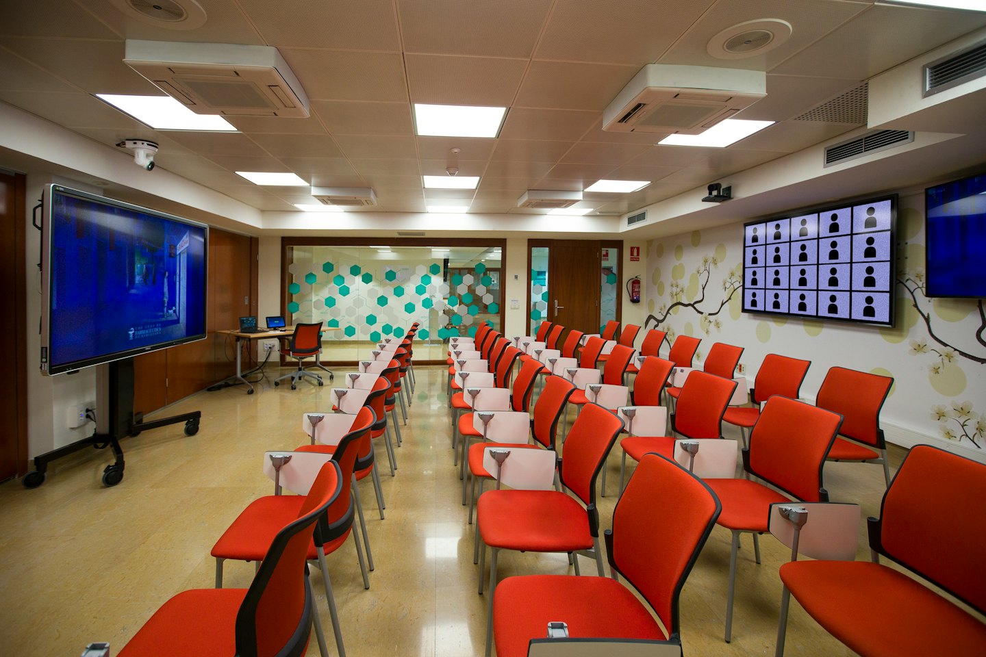 Modern conference room set up for online learning with chairs and screens.